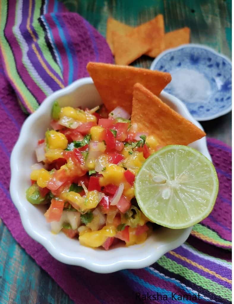 Freshly prepared mango salsa served with tortilla chips as a summer appetizer.