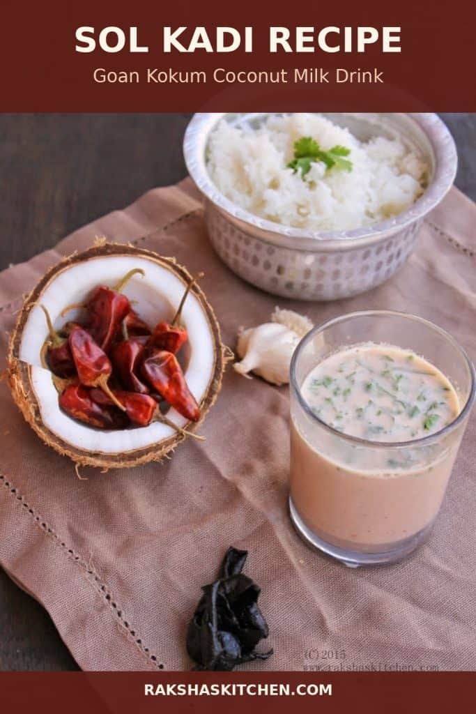 Glass of Goan sol kadi kokum coconut milk drink with rice, dried red chilies, garlic and coconut on a table