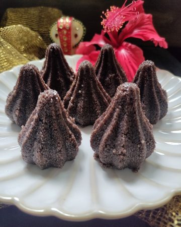 Close-up of chocolate rava mixture being filled into a modak mould.