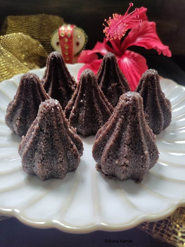Close-up of chocolate rava mixture being filled into a modak mould.
