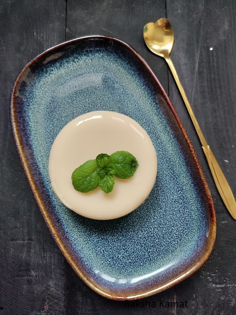Homemade tender coconut pudding topped with mint and coconut chunks.